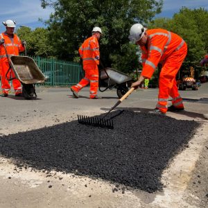 Highways wokers fixing pothole group